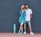 Interracial young couple in love outdoor whis skateboard. Stunning sensual outdoor portrait of young stylish fashion couple posing