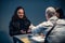 Interrogation of a homicidal maniac in the interrogation room. A police detective sits at a table with a suspect.