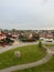 Intersection with cars, green lawns and suburban houses in the background