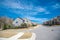 Intersection of large residential streets with row of upscale new development two story suburban houses shingle roofs under sunny