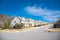 Intersection of large residential streets with row of upscale new development two story suburban houses shingle roofs under sunny