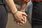 intertwined hands of lesbian couple with a rainbow bracelet