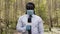 Interview shot. African reporter with face medical mask and gloves in the forest