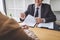 Interviewer or Board reading a resume during a job interview, Employer interviewing a young female job seeker for recruitment