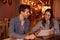 Intimately smiling millenial couple in restaurant