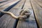 intricate sailing knot on a weathered rope against a wooden deck background