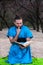 Intrigued handsome bearded man in blue kimono with finger in mouth sitting with book