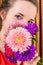 Intriguing girl with bouquet of asters on background of a golden curtain