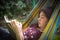 Introvert teenager girl reading book in hammock