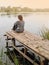 Introvert woman sits on edge of pier