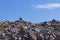 Inukshuk cairn on top of stone hill against blue sky