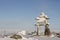 Inukshuk or Inuksuk landmark covered in snow found on a hill in the community of Rankin Inlet, Nunavut