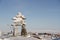 Inukshuk or Inuksuk landmark covered in snow found on a hill in the community of Rankin Inlet, Nunavut