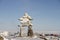 Inukshuk or Inuksuk landmark covered in snow found on a hill in the community of Rankin Inlet, Nunavut