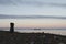 Inuksuk along arctic shore with barge in background