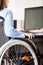 Invalid or disabled woman sitting wheelchair working office desk computer