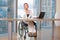 Invalid or disabled young business woman person sitting wheelchair working in office on a laptop