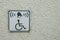 Invalid on wheelchair and ring bell sign on the wall. Disabled people help with copy space for text