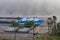 Inverted blue boats on a pier on a foggy morning on a river