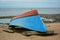 Inverted blue-red boat on the beach