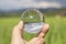 Inverted sky and paddy field view in a lens ball holding by a hand