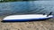 Inverted SUP, surfboard lies on the river Bank.