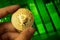 Invest in bitcoin concept background, crypto currency coin in hand close-up, green stock chart photo
