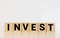 invest word written on wood block