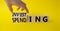 Investing and Spending symbol. Businessman hand. Turned cubes with words Investing and Spending. Beautiful yellow background.