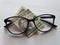 investment and promotion for a better vision, American banknote of five dollars and black plastic frame glasses