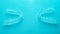 Invisible dental teeth brackets tooth aligners on turquoise background. Plastic braces dentistry retainers to straighten teeth