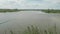 Invisible fisher man casts fishing rod into pond. Increadible faraway view of river bank and village.