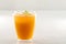 An inviting glass full of orange juice with a fresh mint leaf that floats on white background