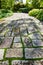 Inviting Rustic Garden Path with Lush Greenery and Stone Slabs