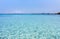 Inviting turquoise mediterranean sea with reflections - mountain range and rocks in the background, Capriccioli beach, Sardinia, I