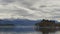 ioannina lake in winter season boats traveling cloudy day snow on the mountains in greece