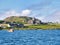 Iona Abbey, cottages and a fishing boat on a sunny day in Autumn from the Sound of Iona
