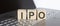 IPO abbreviation stands for written on a wooden cube on laptop