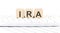 IRA -word wooden block on keyboard background witn chart