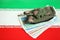 Iranian army toy tank drive on iranian bills of rial currency on flag of Islamic Republic of Iran