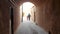 Iranian father and his daughter walking in the traditional narrow alley with arches in the old town of Yazd, Iran
