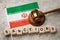 Iranian flag, judge`s gavel and wooden cubes with text, concept on the topic of sanctions in Iran