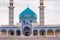 Iranian mosque in traditional colors with ornaments, blue roof and two minarets