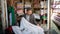 Iranian old man selling textiles in in his small shop in Grand Bazaar of Isfahan, Iran