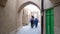 Iranian people walking in the traditional narrow alley with arches in the old town of Yazd, Iran