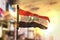 Iraq Flag Against City Blurred Background At Sunrise Backlight