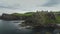 Ireland ancient castle ruin aerial view on basalt cliff above ocean bay. Panning fly over stone fort