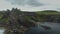 Ireland Dunluce castle ruins aerial shot on greenery basalt`s cliff. Panning flight above fortress