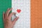 Ireland flag is depicted on a puzzle, which the man`s hand completes to fold