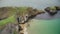 Ireland people ocean bay aerial view: tourists walking on Carrick Islet, Carrick-a-Rede Rope Bridge